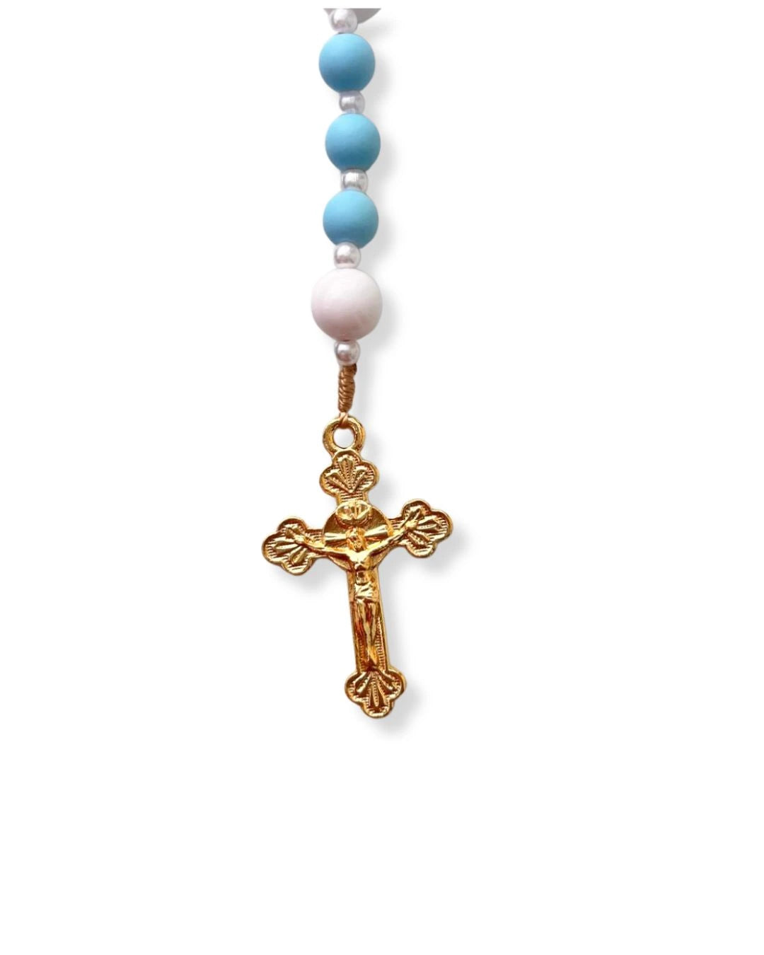Close do crucifixo dourado do terço católico de Nossa Senhora das Graças, com detalhes em alto relevo e acabamento brilhante. As contas azul-turquesa e brancas complementam o design clássico.
